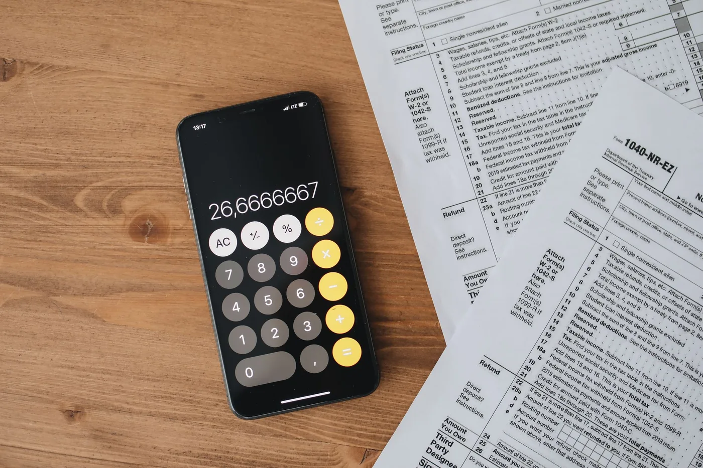 Kalkulačka na mobilu vedle daňových formulářů