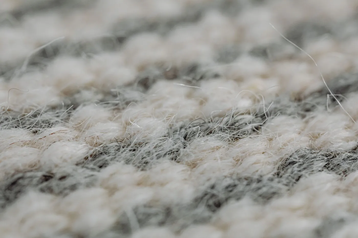 Detail textury vlněného koberce zblízka