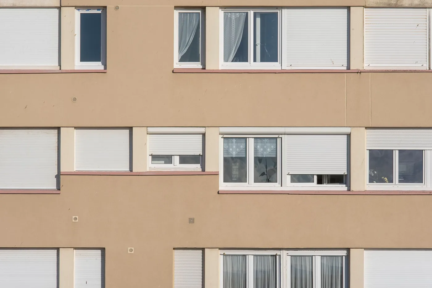 Fasáda paneláku s okny a roletami