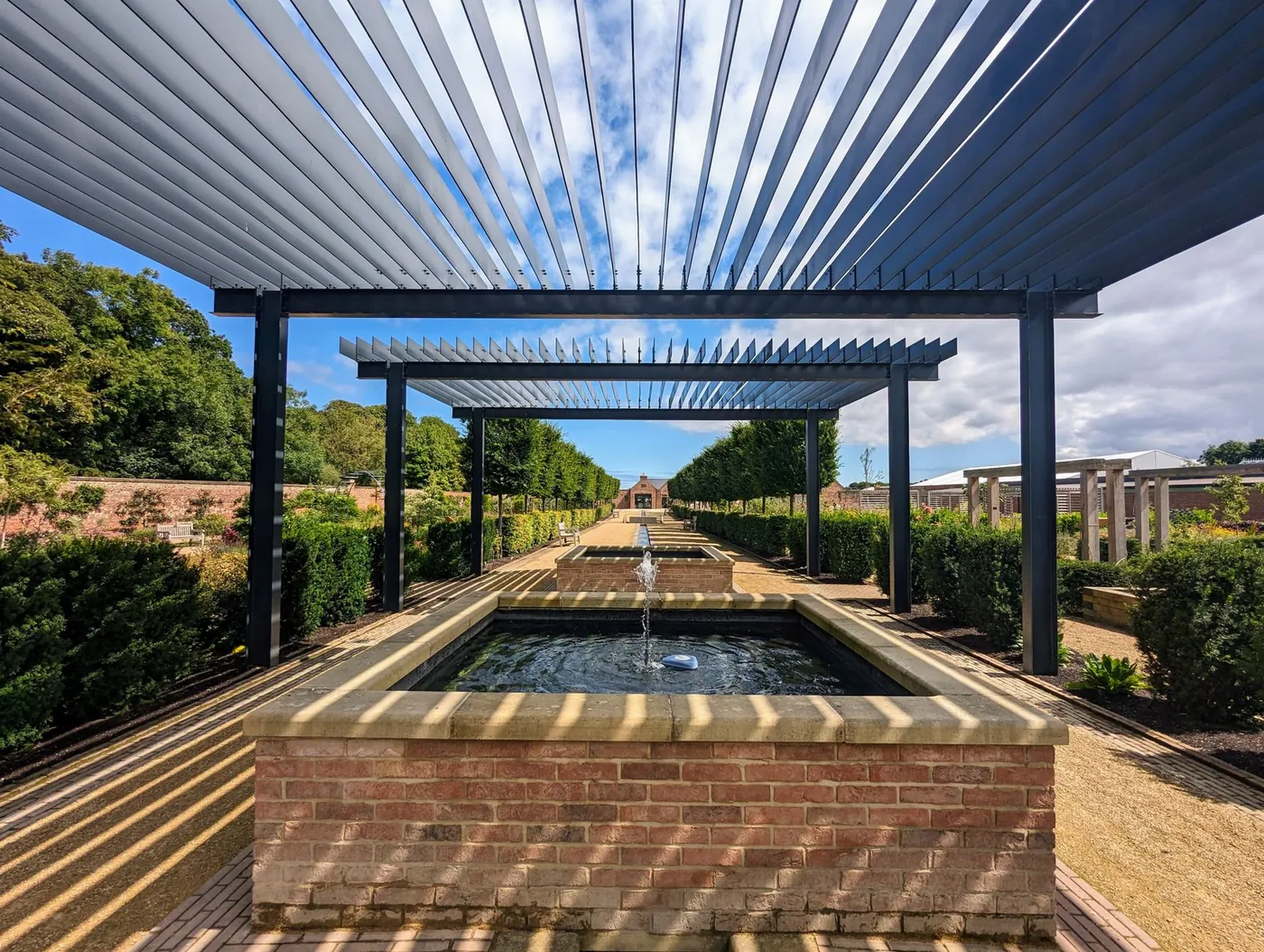 Hliníková pergola s lamelami nad zahradním jezírkem