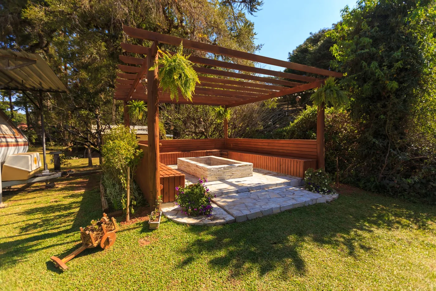 Dřevěná pergola se sedací zónou na zahradě