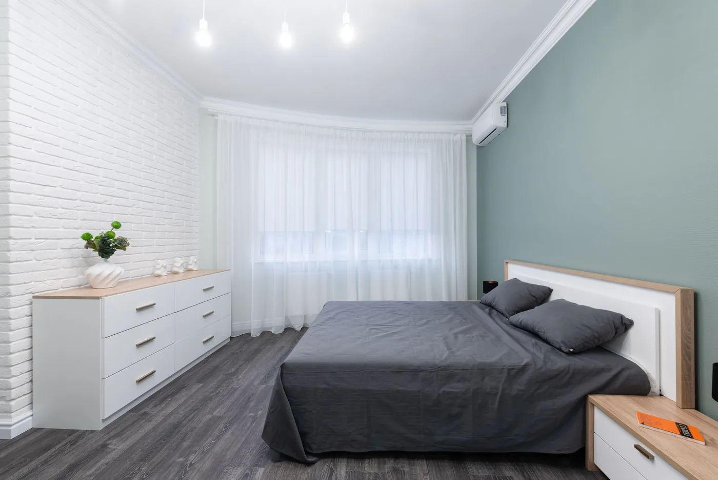 Ložnice s dvojlůžkem a bílou komodou