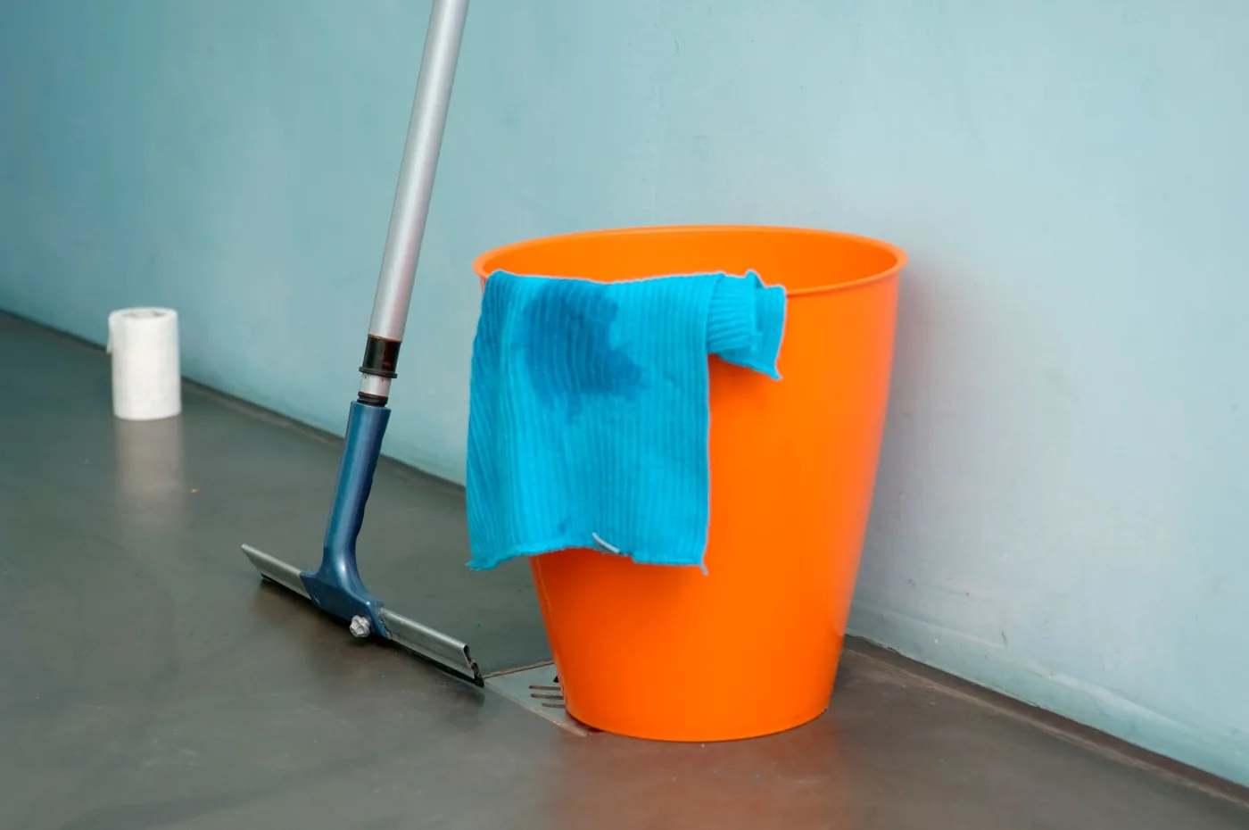 Mop a oranžový kbelík s hadrem na podlaze