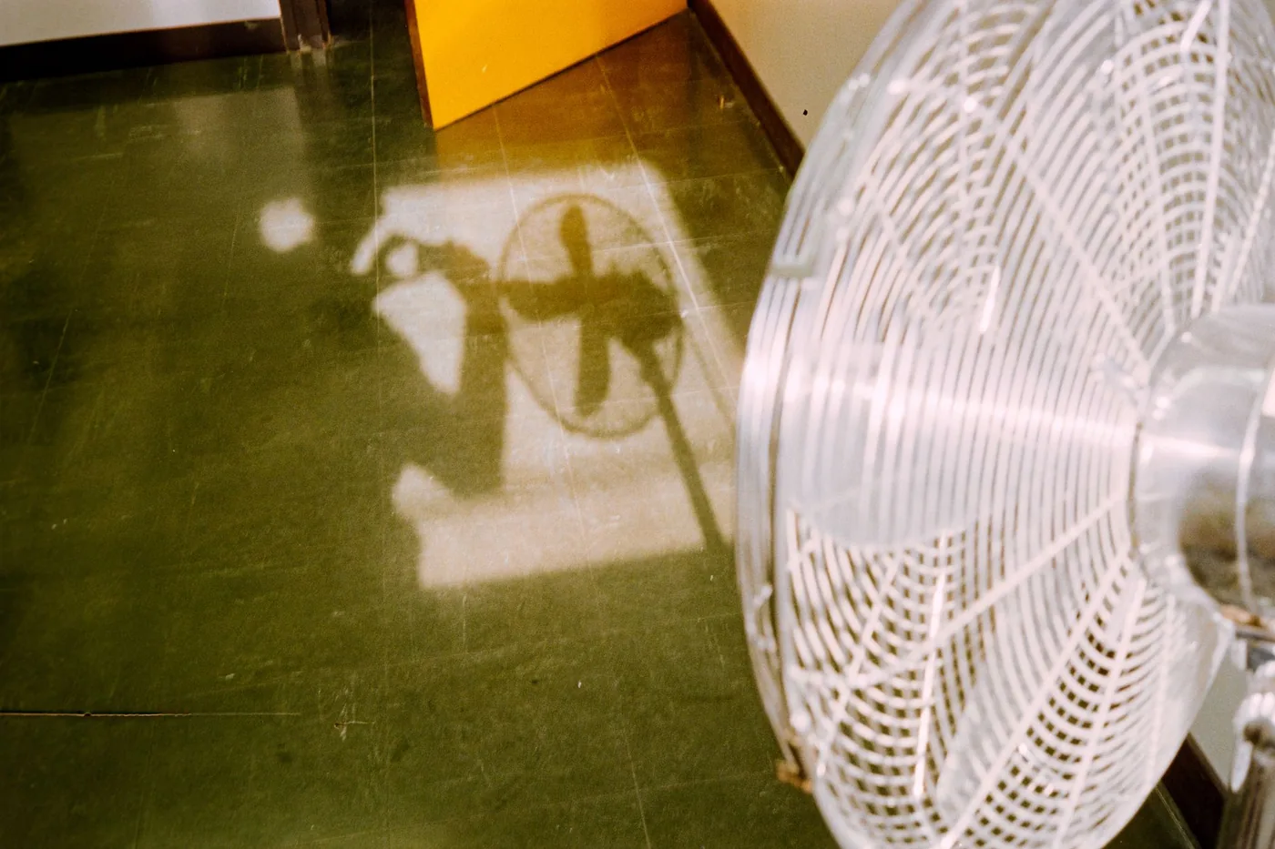 Bílý stojanový ventilátor zblízka na podlaze