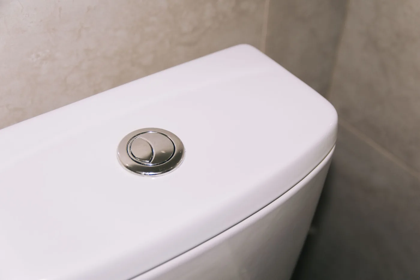 Detail splachovacího tlačítka na nádržce WC